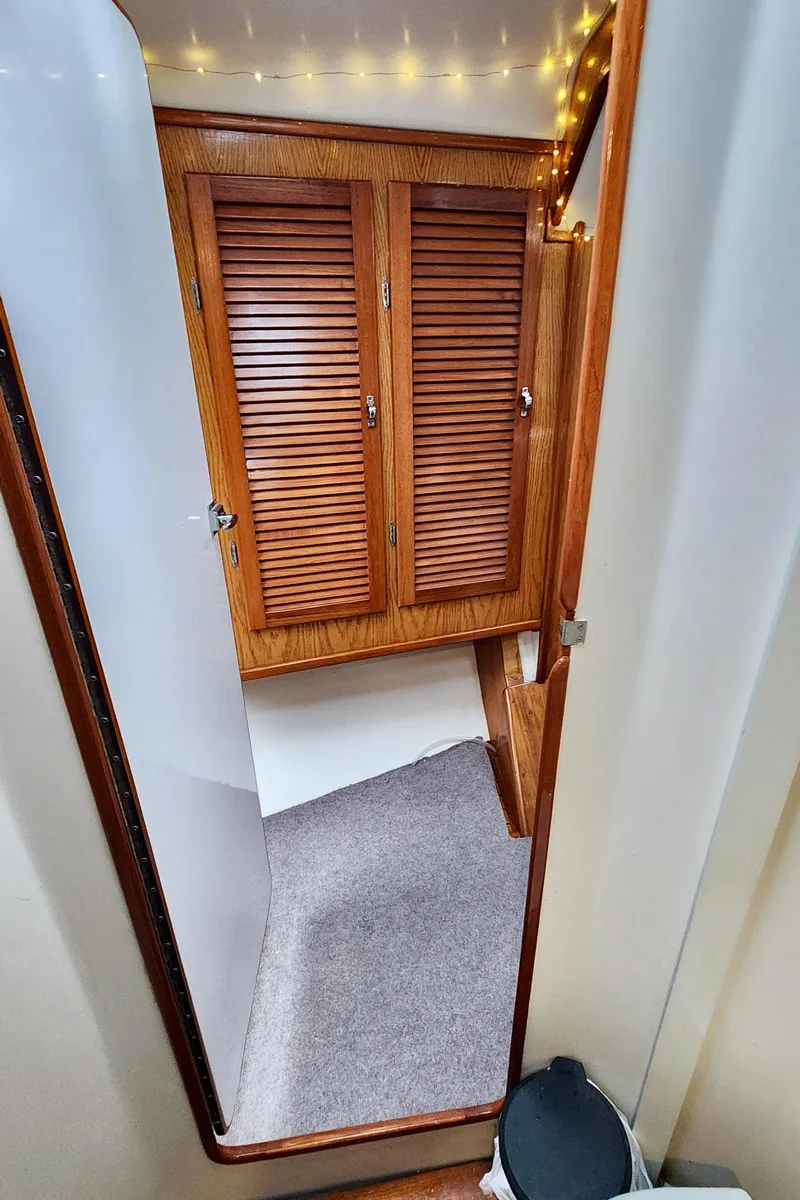 Slide: The Image of Interior of 1985 Farr 50 yacht with wooden cabinets and carpeted flooring. - 24