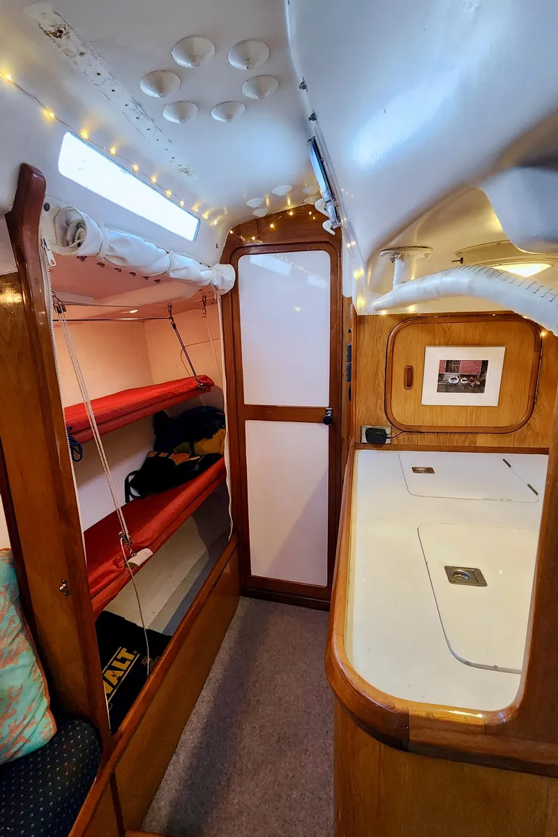 Slide: The Image of Interior of a 1985 Farr 50 yacht with wooden finishes and red bunk beds. - 27