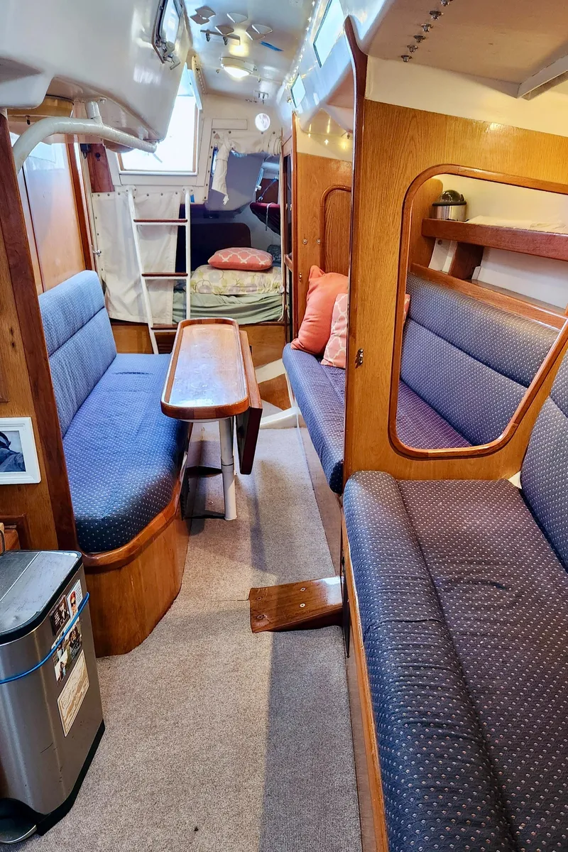 Slide: The Image of Interior of a 1985 Farr 50 sailboat with cozy seating and wooden accents. - 28