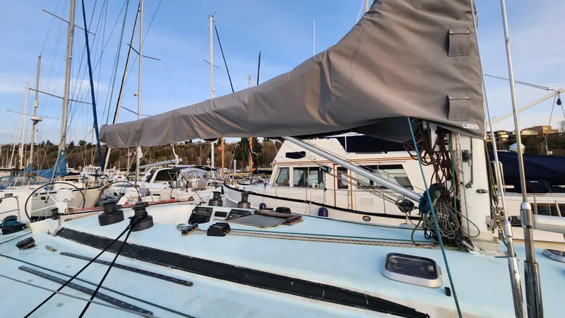Slide: The Image of 1985 Farr 50 sailboat docked in marina, featuring covered boom and rigging. - 3