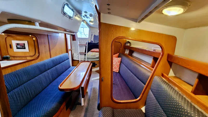 Slide: The Image of Interior of 1985 Farr 50 yacht with blue seating and wooden accents. - 30