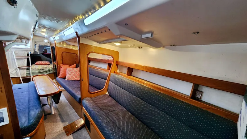 Slide: The Image of Interior of a 1985 Farr 50 yacht with cozy seating and wooden accents. - 31