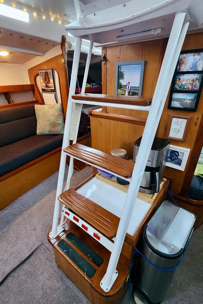 Slide: The Image of Interior of 1985 Farr 50 yacht with wooden steps and cozy seating area. - 32