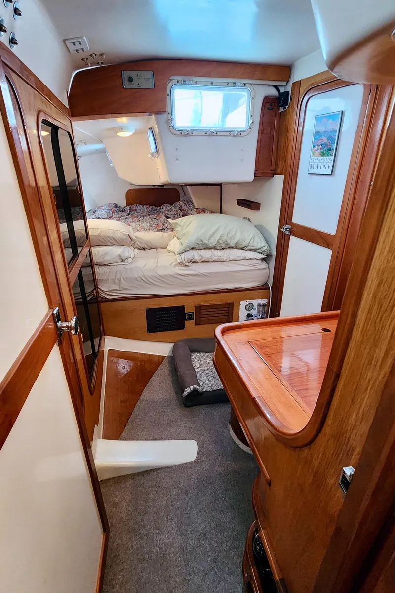 Slide: The Image of Cozy cabin interior of 1985 Farr 50 yacht with wooden furnishings and a comfortable bed. - 34
