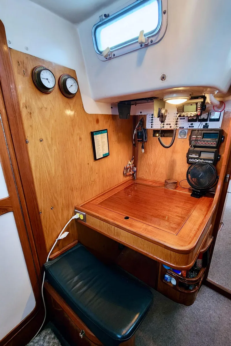 Slide: The Image of Navigation station in a 1985 Farr 50 yacht with wooden desk, instruments, and seating. - 35