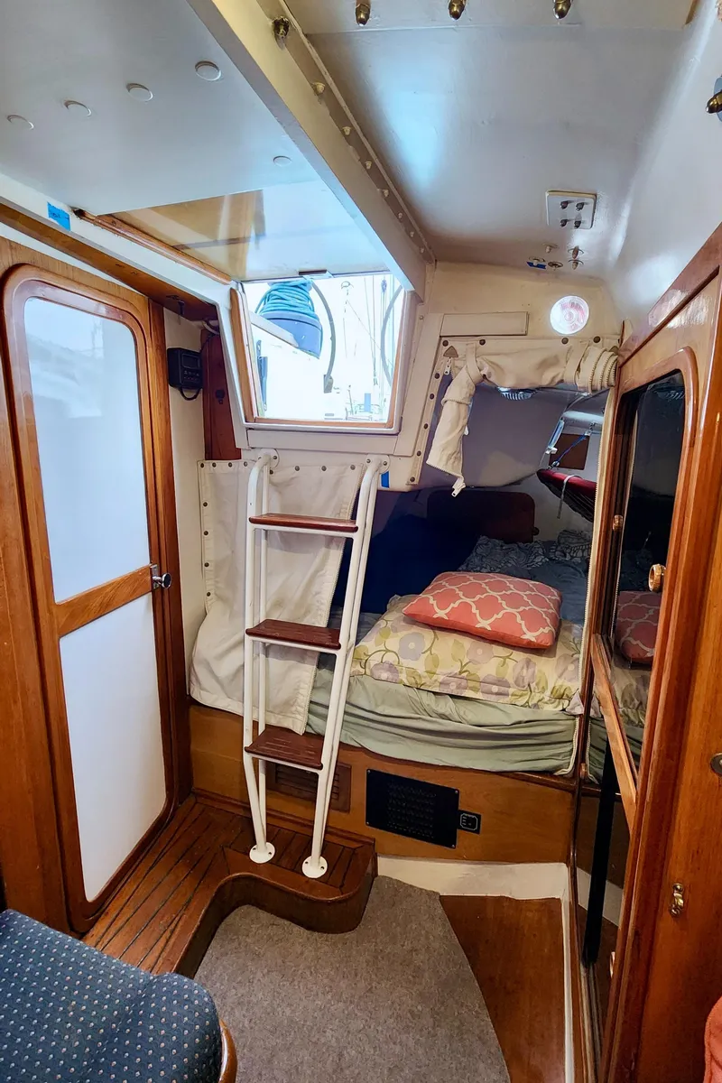 Slide: The Image of Cozy cabin interior of a 1985 Farr 50 sailboat with wooden accents and a comfortable bed. - 38
