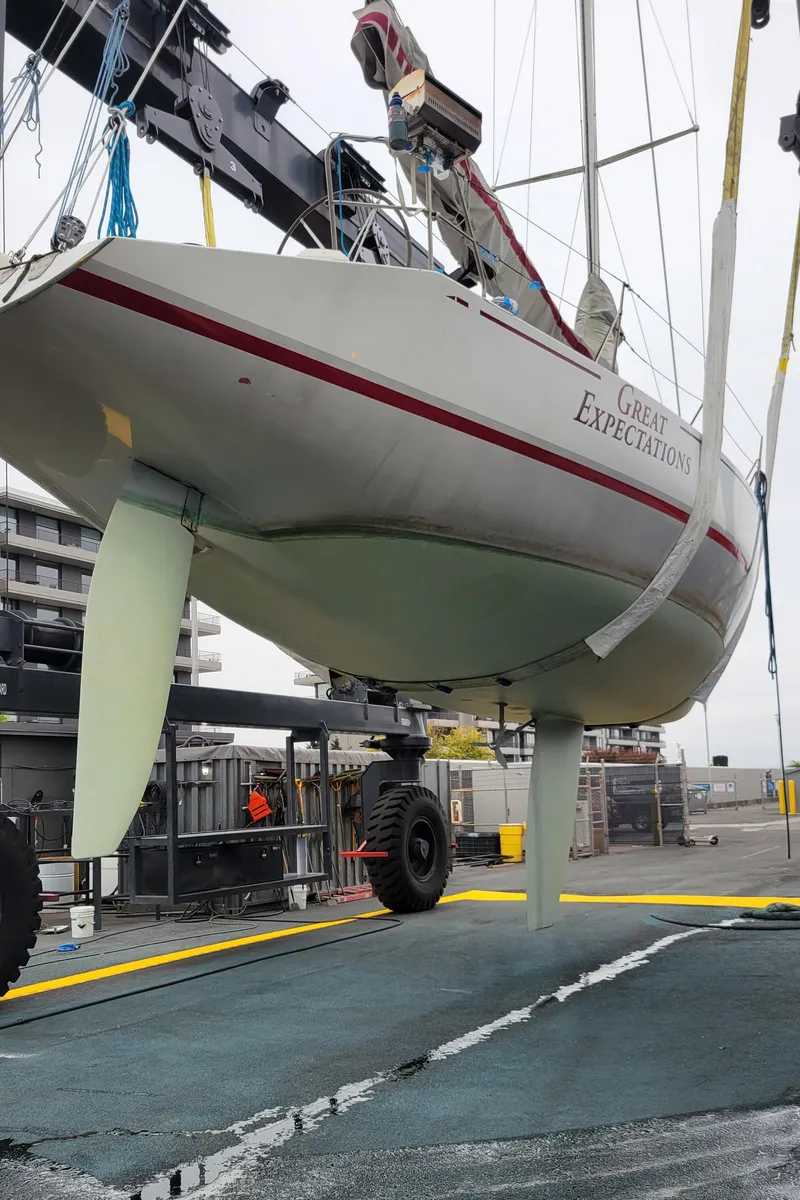 Slide: The Image of 1985 Farr 50 sailboat lifted by crane at a marina. - 40