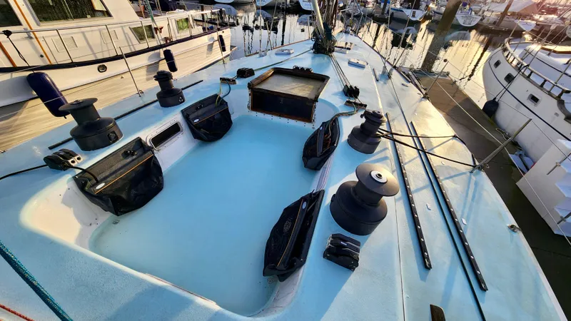 Slide: The Image of 1985 Farr 50 sailboat deck with winches and ropes in a marina setting. - 7