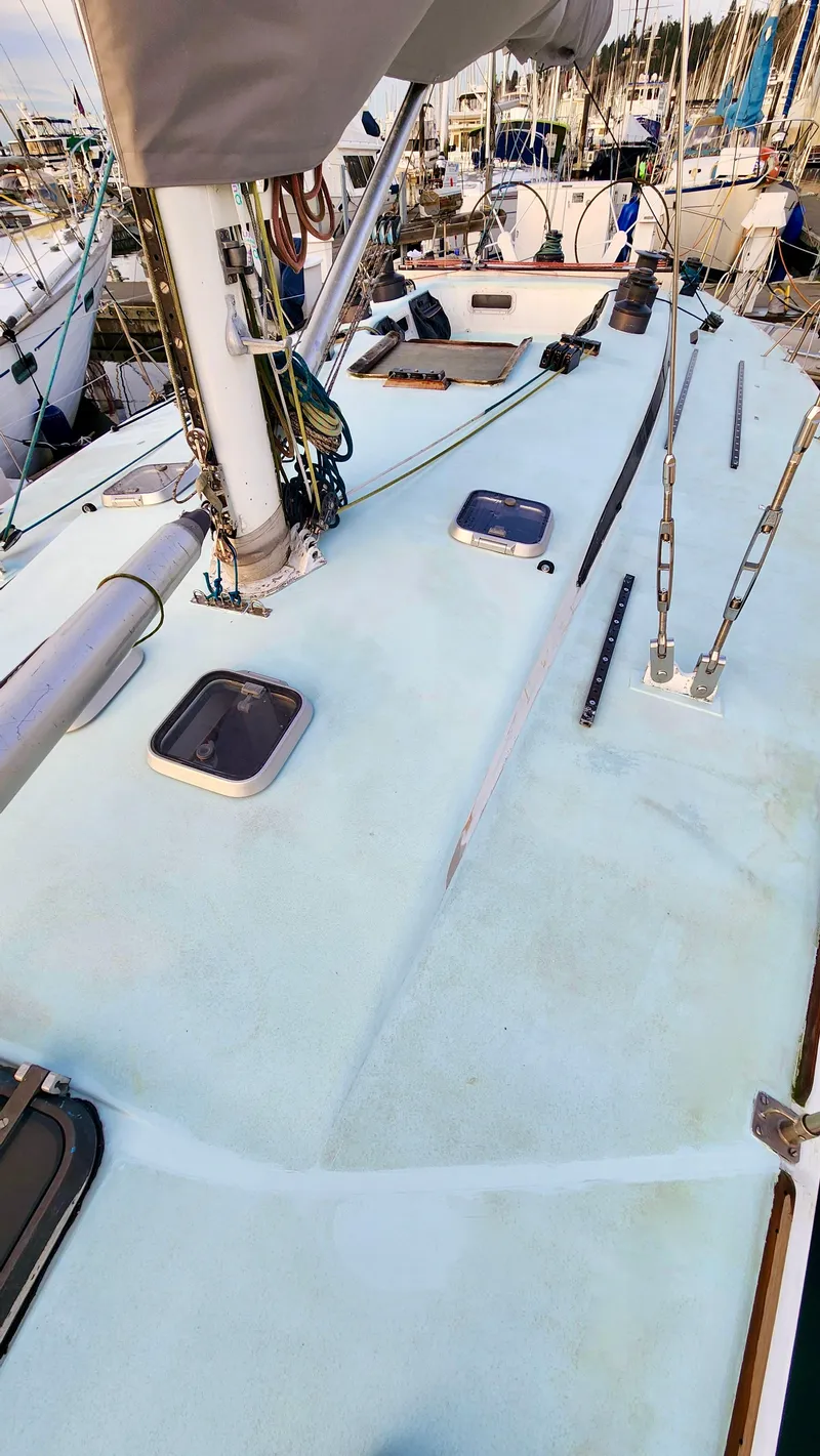 Slide: The Image of 1985 Farr 50 sailboat deck with hatches and rigging in a marina. - 9