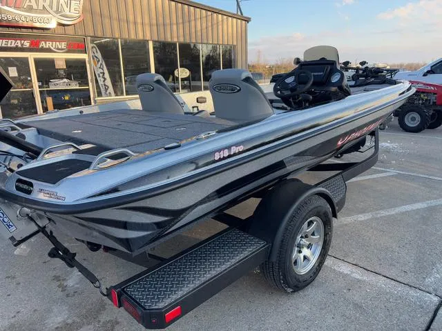 Slide: The Image of 2025 Phoenix 818 Pro fishing boat on trailer, parked outside a marine shop. - 5
