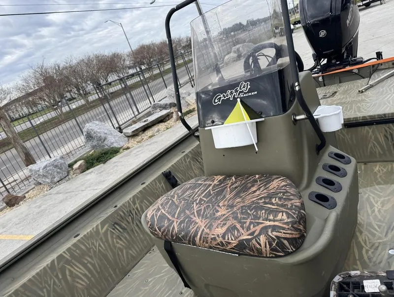 Slide: The Image of 2020 Tracker Grizzly 1860 CC boat with camo seat and console, parked outdoors. - 10