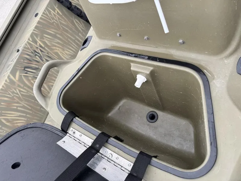 Slide: The Image of 2020 Tracker Grizzly 1860 CC boat storage compartment with drain plug. - 12