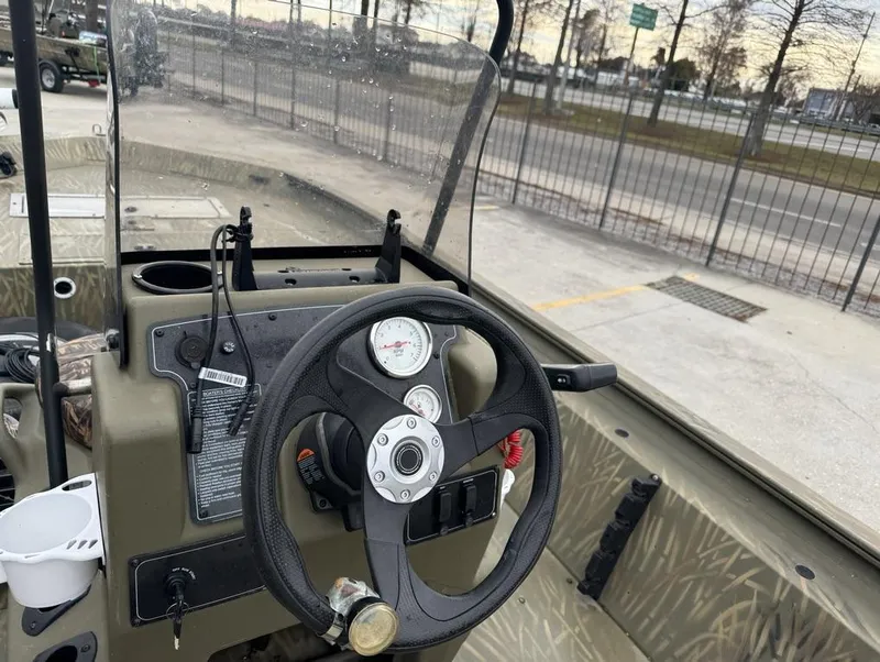 Slide: The Image of 2020 Tracker Grizzly 1860 CC boat dashboard with steering wheel and gauges. - 13