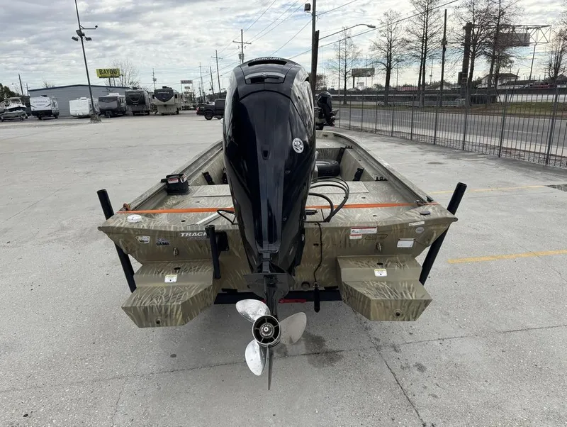 Slide: The Image of 2020 Tracker Grizzly 1860 CC boat with outboard motor in a parking lot. - 7