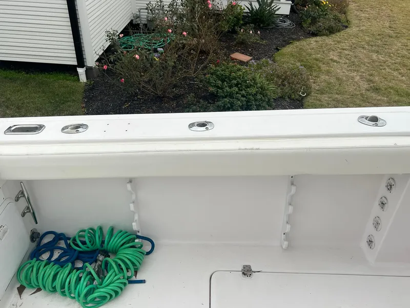 Slide: The Image of 2001 Donzi 32 ZF Open boat deck with coiled green rope, garden in background. - 44