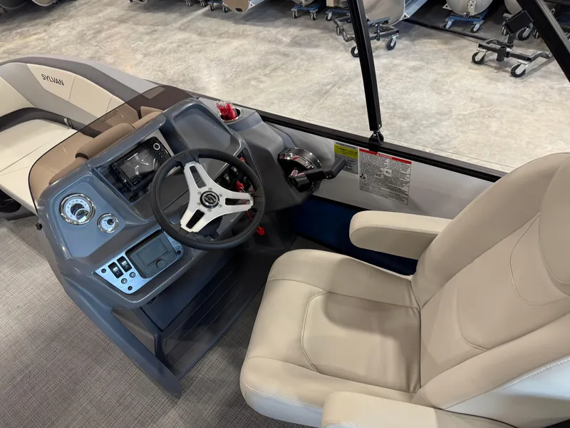 Slide: The Image of 2025 Sylvan A-22 Sport boat interior with steering wheel and beige seating. - 9