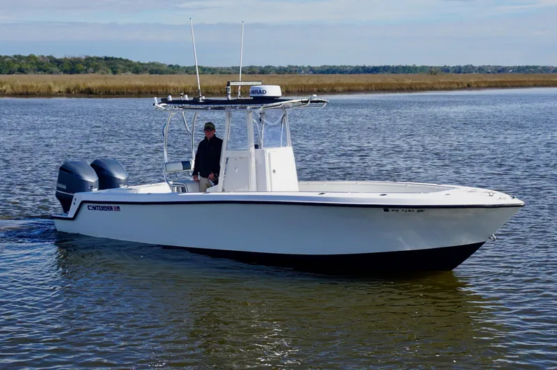 Slide: The Image of 1998 Contender 25 Open boat on calm water, featuring dual engines and center console. - 4