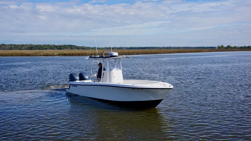 Slide: The Image of 1998 Contender 25 Open boat cruising on a calm river under a blue sky. - 5