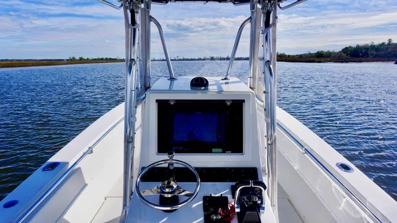 Slide: The Image of 1998 Contender 25 Open boat on calm water, featuring a central console and steering wheel. - 6