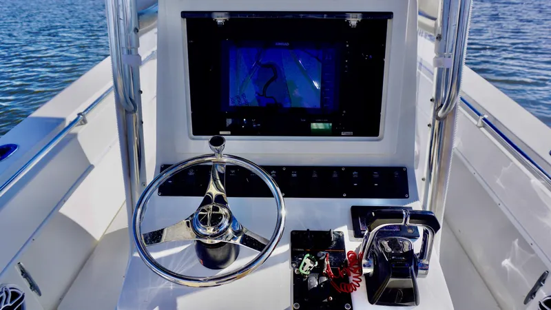 Slide: The Image of 1998 Contender 25 Open boat dashboard with steering wheel and navigation screen. - 7