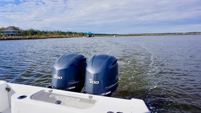 Slide: The Image of 1998 Contender 25 Open boat with twin 300 horsepower engines on a calm waterway. - 8