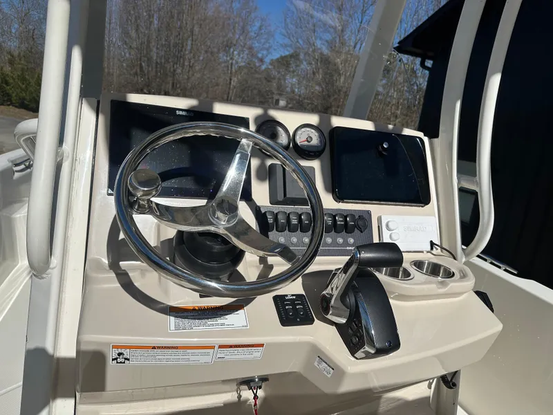Slide: The Image of 2023 Boston Whaler 250 Dauntless boat console with steering wheel and controls. - 11