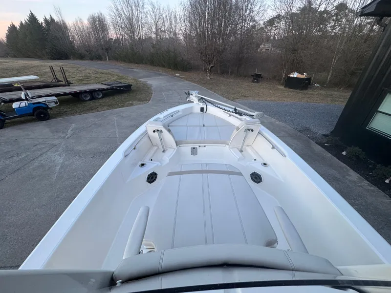 Slide: The Image of 2023 Boston Whaler 250 Dauntless boat on a driveway, surrounded by trees. - 5