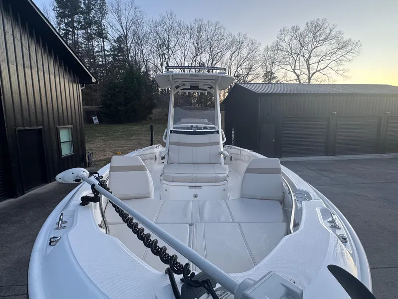 Slide: The Image of 2023 Boston Whaler 250 Dauntless boat docked near black buildings at sunset. - 6