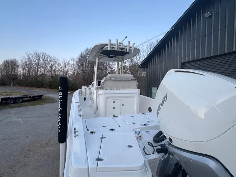 Slide: The Image of 2023 Boston Whaler 250 Dauntless boat with Mercury engine, parked outdoors near a building. - 7