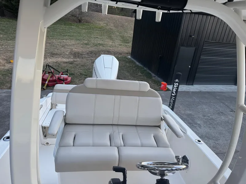 Slide: The Image of 2023 Boston Whaler 250 Dauntless boat interior with cushioned seating and steering wheel. - 8