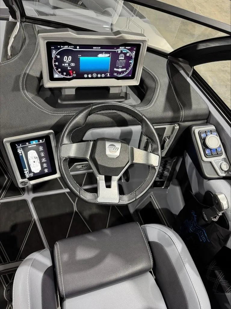 Slide: The Image of 2024 Malibu M242 boat dashboard with modern steering wheel and digital displays. - 13