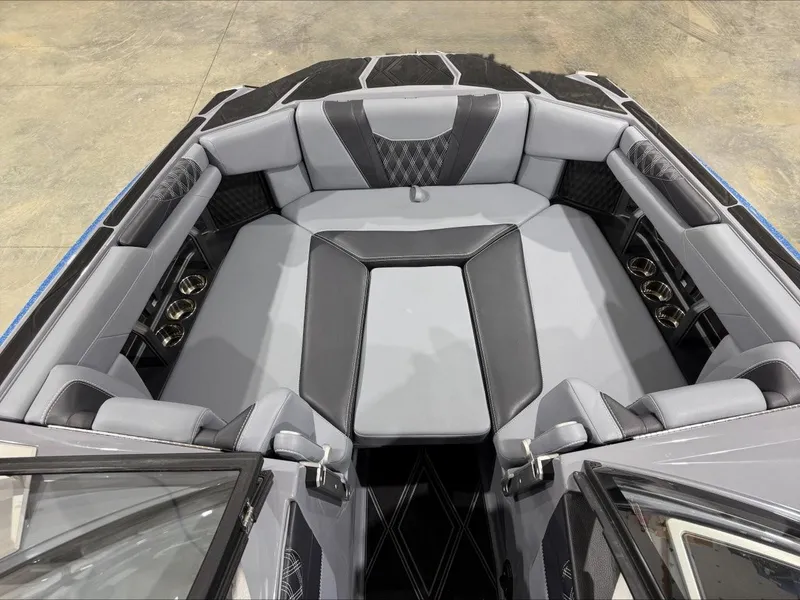Slide: The Image of 2024 Malibu M242 boat interior with luxurious gray seating and cup holders. - 17