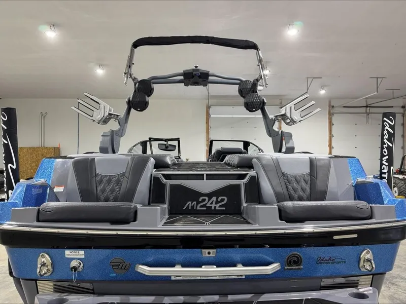 Slide: The Image of 2024 Malibu M242 boat interior with sleek seating and modern design in a showroom. - 3