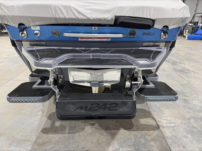 Slide: The Image of 2024 Malibu M242 boat rear view with Power Wedge III and swim platform. - 5