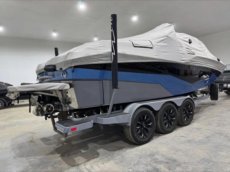Slide: The Image of 2024 Malibu M242 boat on trailer, covered, in indoor storage. - 7