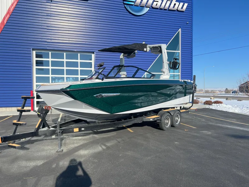 Slide: The Image of 2024 Nautique G25 boat on trailer outside blue building. - 10