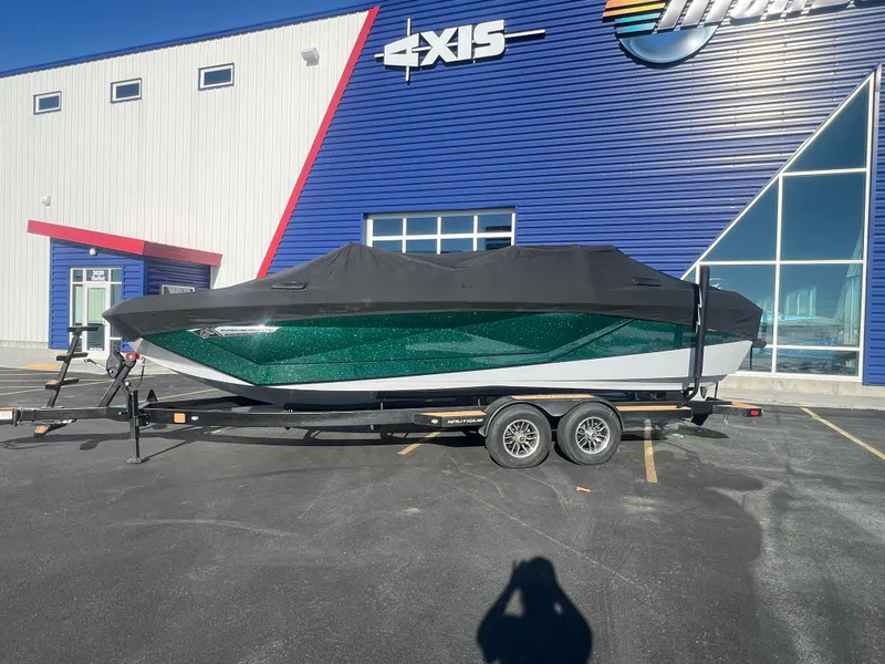 Slide: The Image of 2024 Nautique G25 boat with cover on trailer, parked outside dealership. - 11