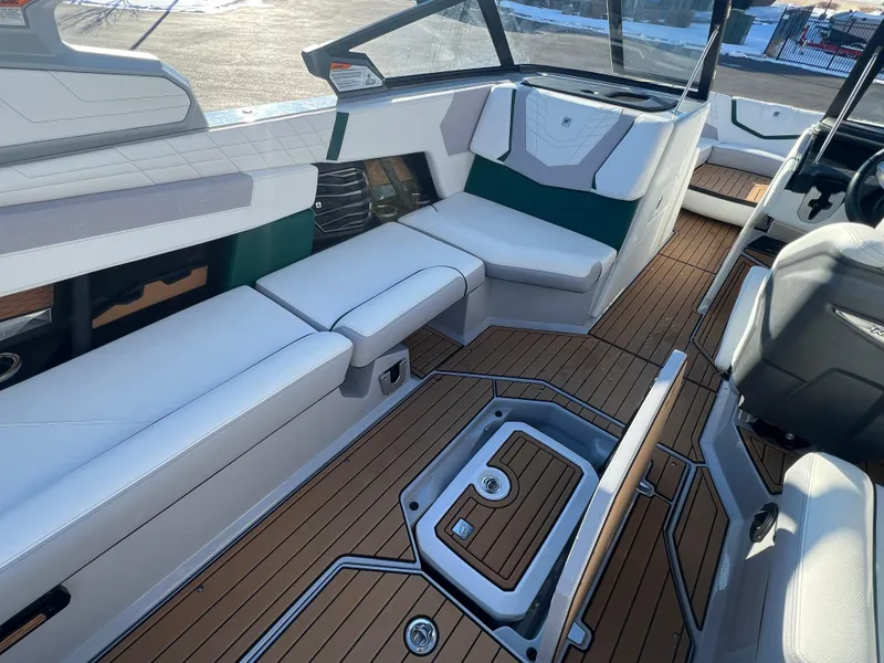 Slide: The Image of 2024 Nautique G25 boat interior with luxurious seating and teak flooring. - 15