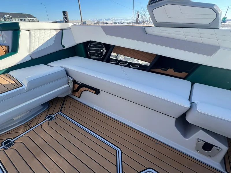 Slide: The Image of 2024 Nautique G25 interior with luxurious seating and teak flooring. - 16