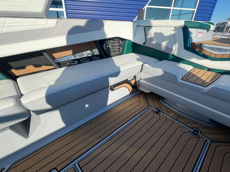 Slide: The Image of 2024 Nautique G25 interior with luxurious seating and teak-style flooring. - 17