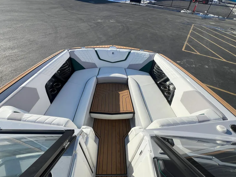 Slide: The Image of 2024 Nautique G25 boat interior with luxurious seating and teak flooring. - 22
