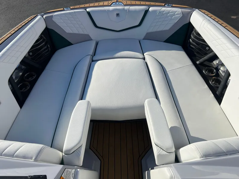 Slide: The Image of 2024 Nautique G25 boat interior with luxurious white seating and cup holders. - 23