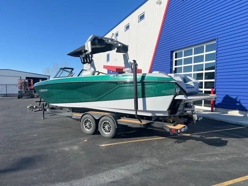 Slide: The Image of 2024 Nautique G25 boat on trailer, parked outside a blue and white building. - 4