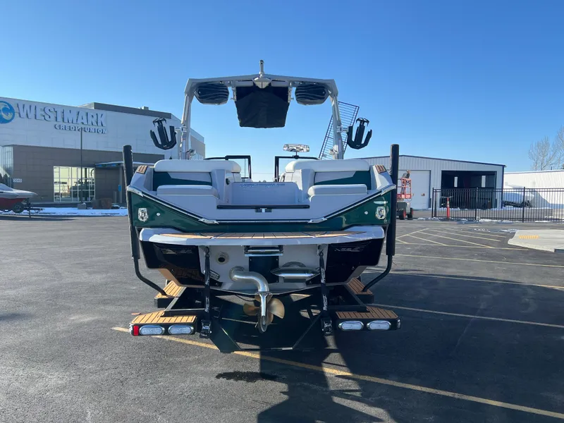Slide: The Image of 2024 Nautique G25 boat rear view in parking lot, clear blue sky background. - 5