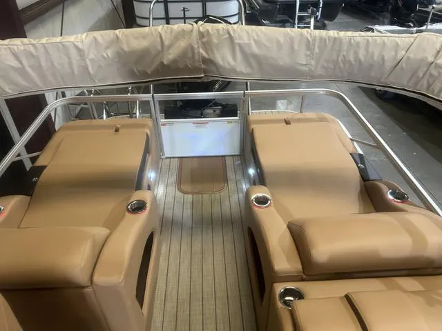 Slide: The Image of 2025 SunCatcher Fusion Series 324SS boat interior with tan seating and wood flooring. - 11