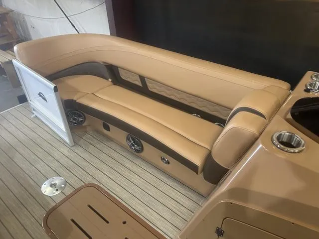 Slide: The Image of 2025 SunCatcher Fusion Series 324SS boat interior with tan seating and wood flooring. - 20