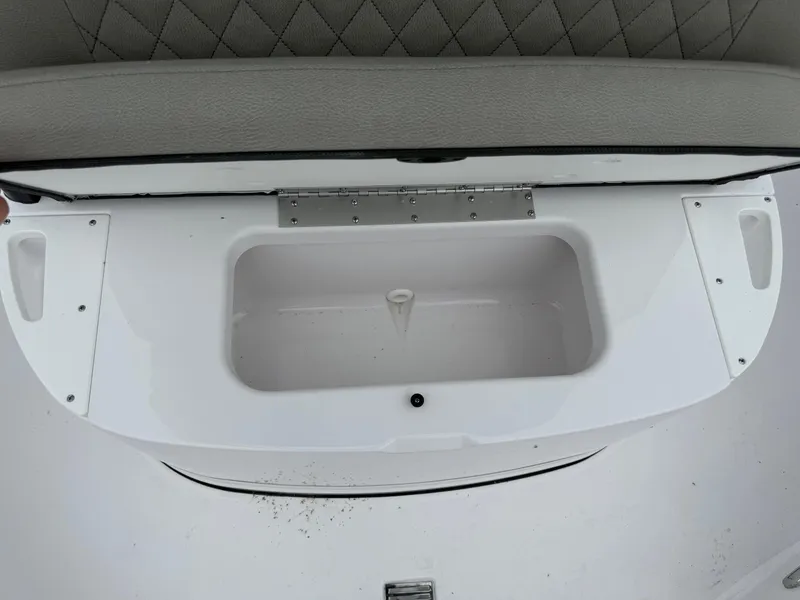 Slide: The Image of 2025 Sportsman Open 212 Center Console boat storage compartment with cushioned seat. - 8