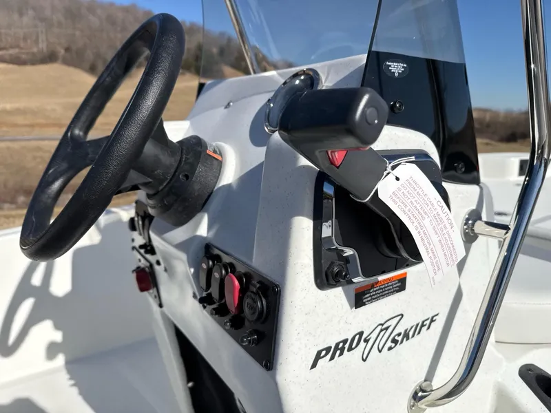 Slide: The Image of 2025 Mako Pro Skiff 17 CC boat console with steering wheel and controls. - 5