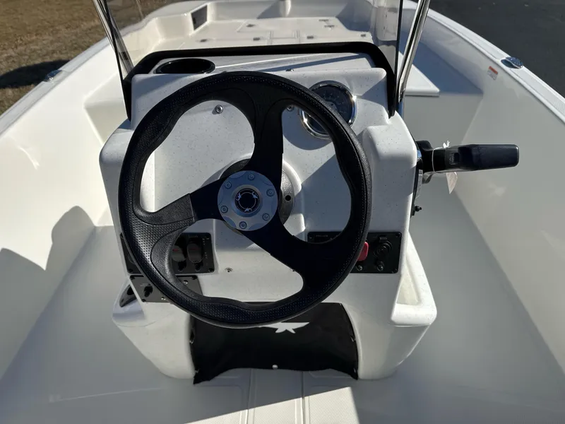 Slide: The Image of 2025 Mako Pro Skiff 17 CC boat steering console with black wheel and controls. - 8