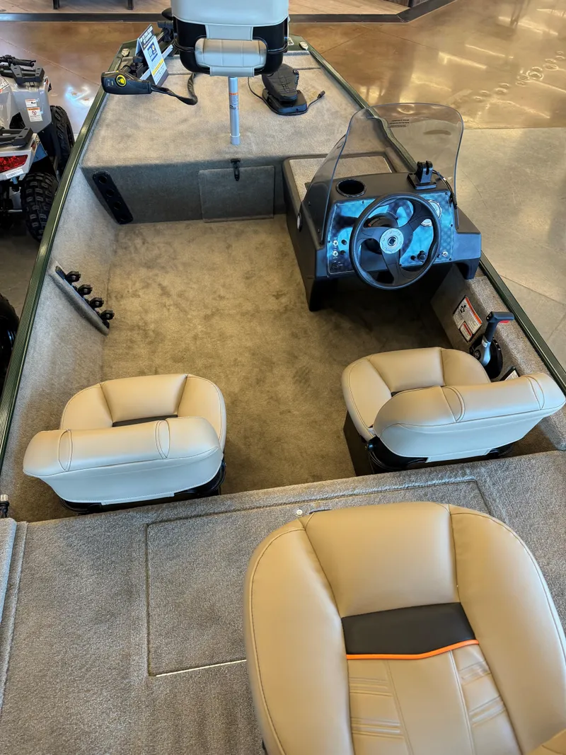 Slide: The Image of 2025 Tracker Bass Tracker Classic Limited interior with beige seating and steering console. - 2